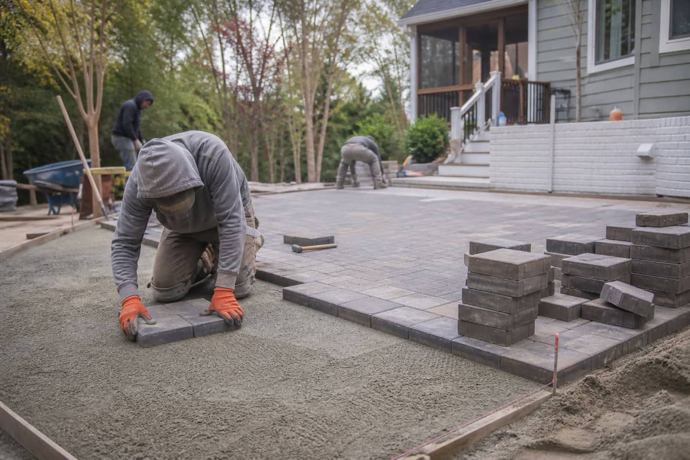 Crew installing concrete pavers on site