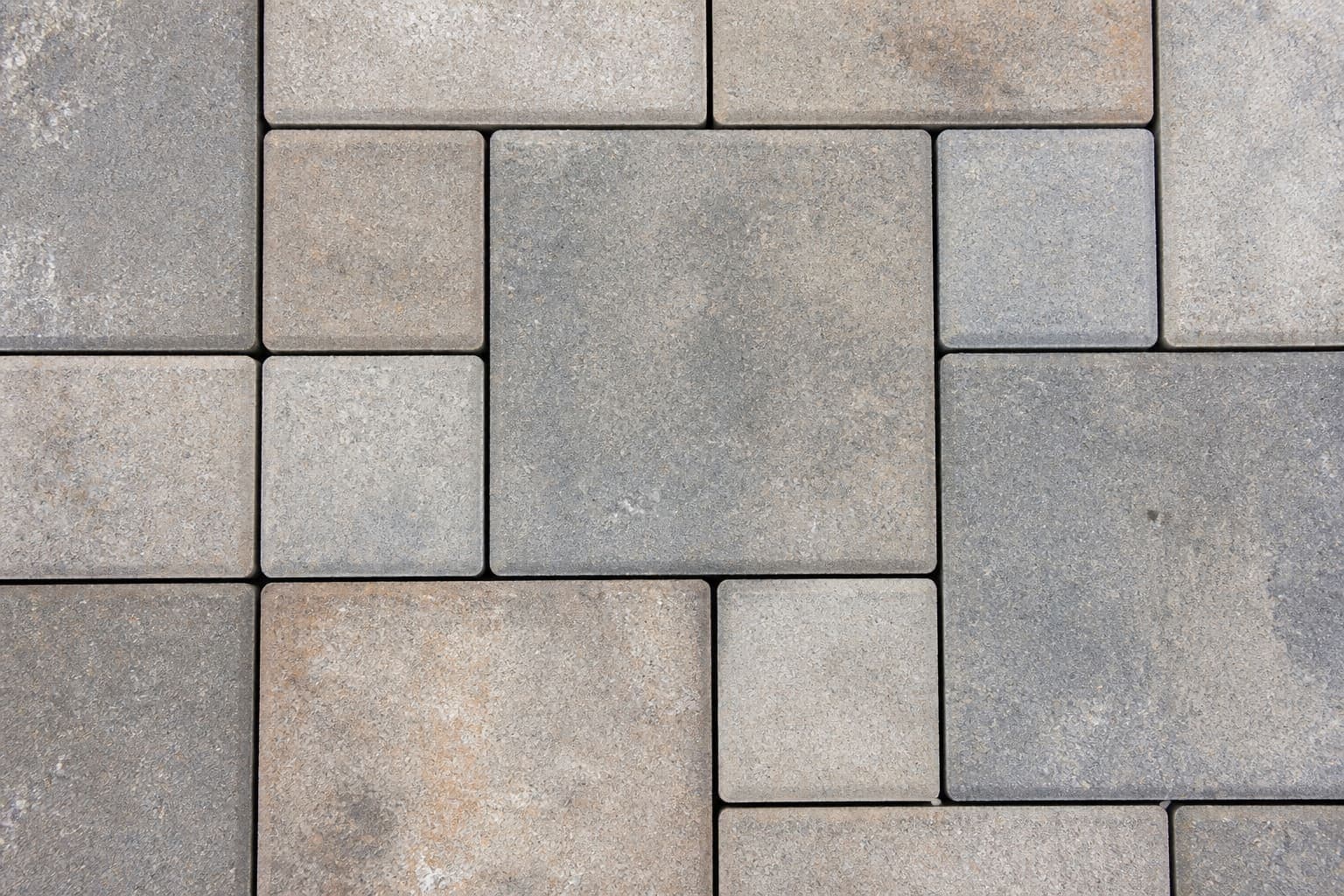 Paver walkway leading to a landscaped patio